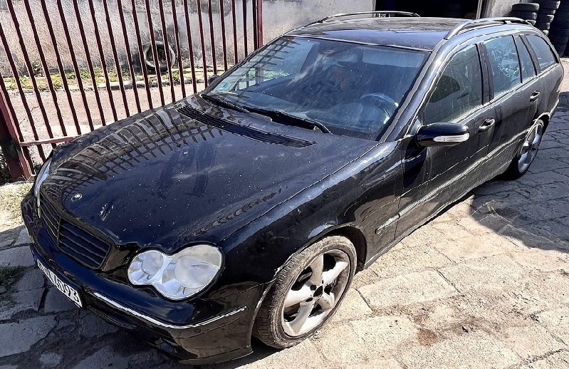 Samochód Mercedes-Benz C 180 w kolorze czarnym widoczny od przodu z prawej strony.
