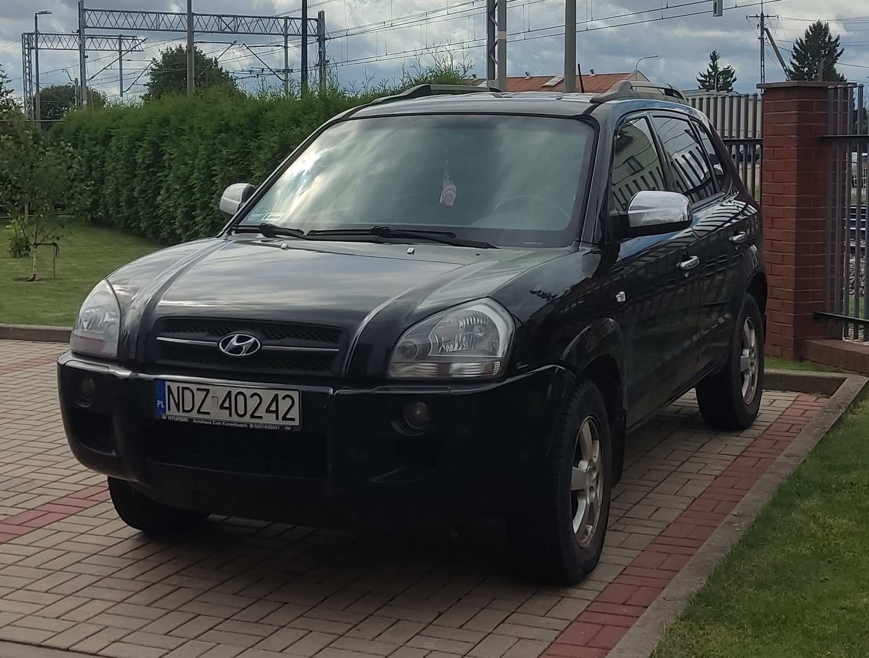 Czarny SUV marki Hyundai Tucson zaparkowany na kostce brukowej.