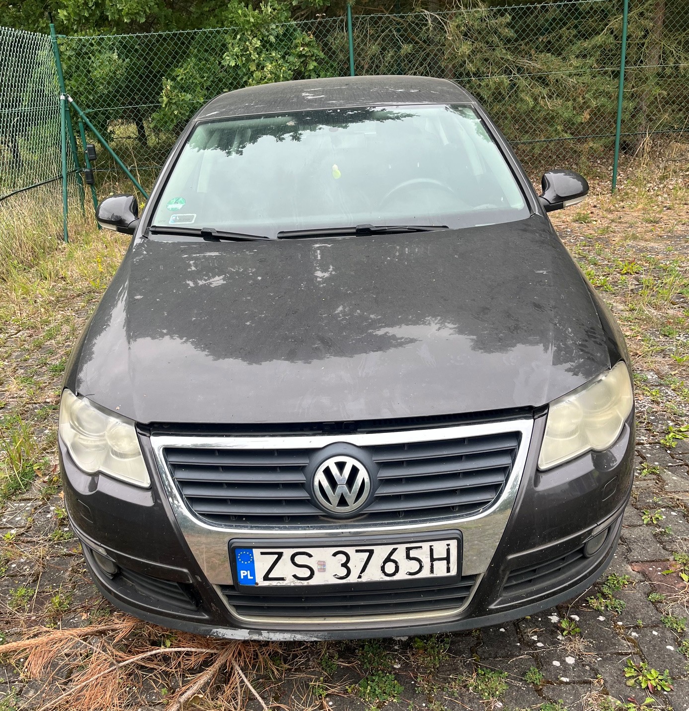 Czarny samochód osobowy marki Volkswagen Passat sfotografowany od przodu na zewnątrz.