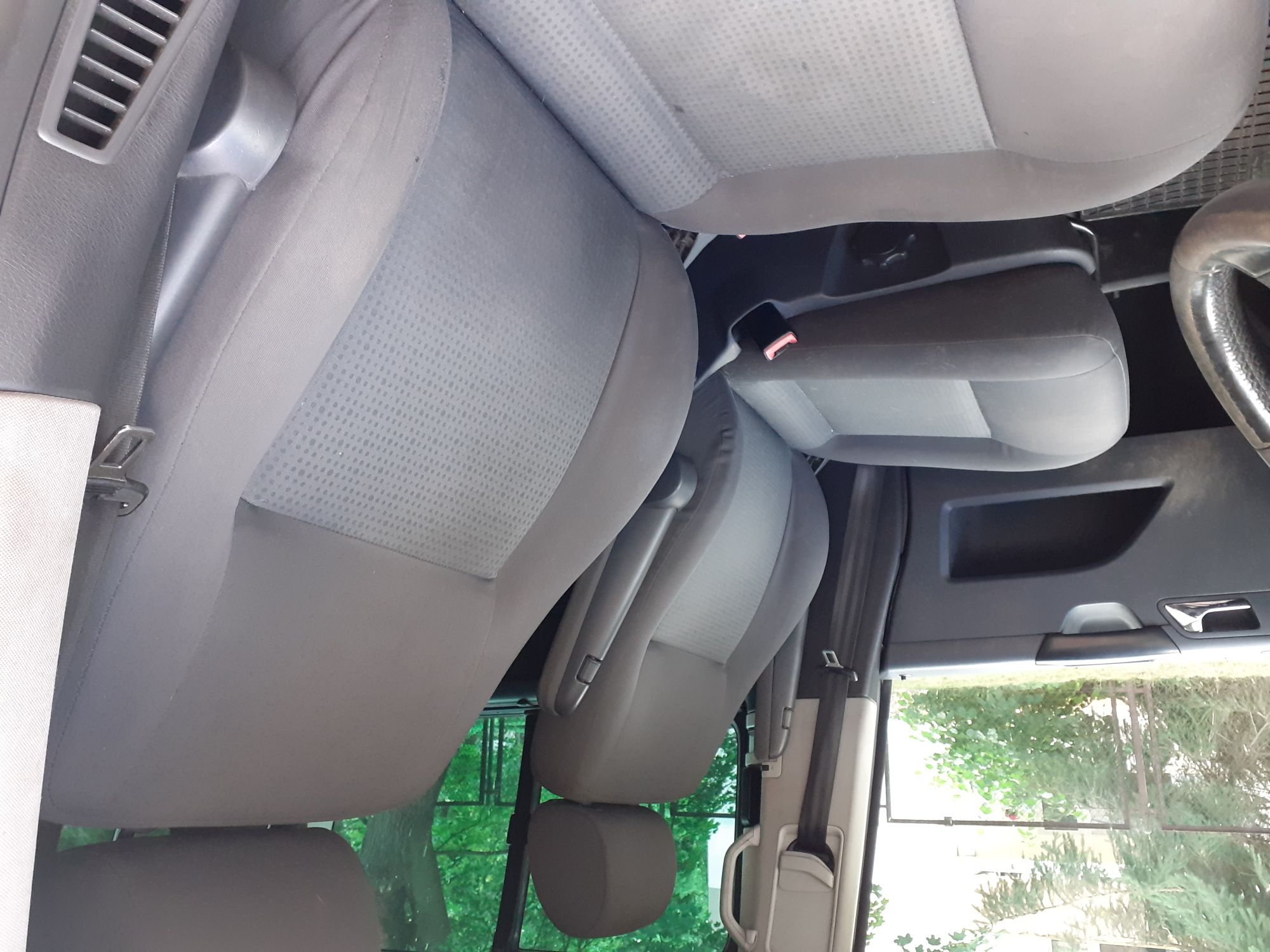 Widok wnętrza pojazdu srebrnego Volkswagena Caravelle od strony kierowcy