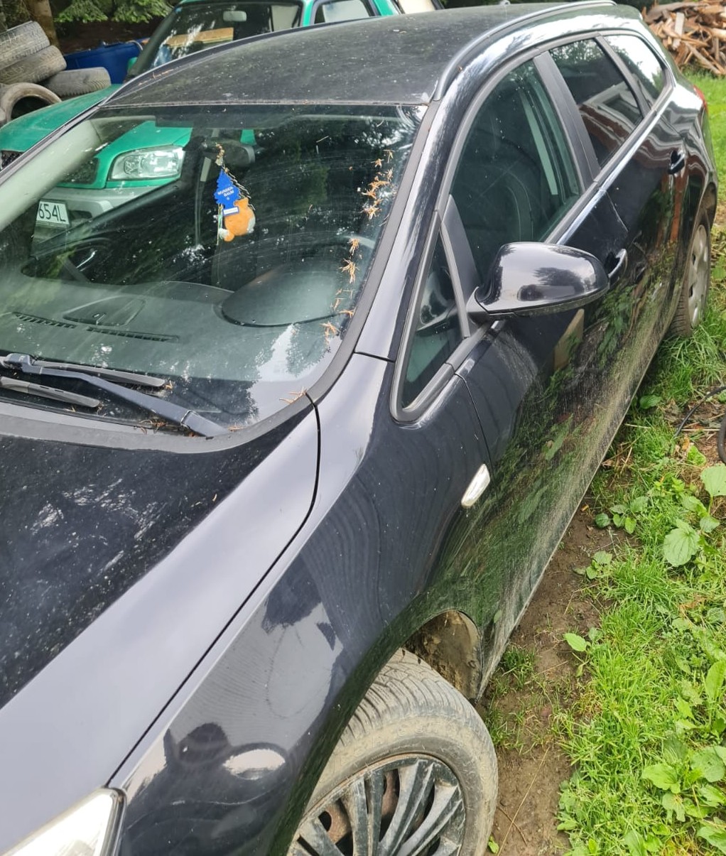 Lewy bok granatowego pojazdu marki Opel Astra.