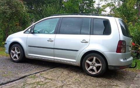 Volkswagen Touran w kolorze srebrnym, 5-drzwiowy minivan z hakiem holowniczym - lewy bok