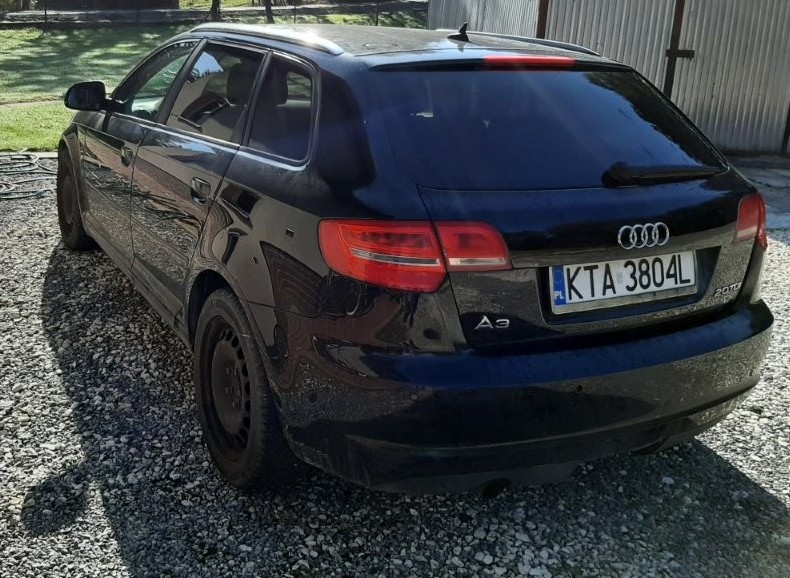 Lewy bok i tył czarnego hatchback Audi A3. Widoczne pięciodrzwiowe nadwozie, czarne felgi stalowe oraz logo na klapie.