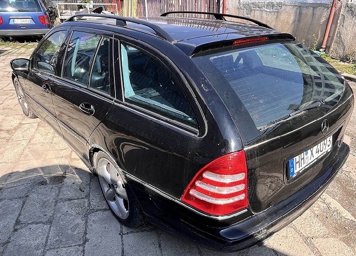 Samochód Mercedes-Benz C 180 w kolorze czarnym widoczny od tyłu z lewej strony.