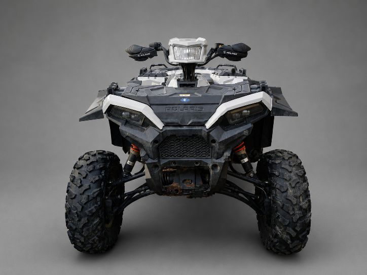 Czarno-szary quad Polaris z pomarańczowymi elementami, widok z przodu, wyposażony w duże, terenowe opony