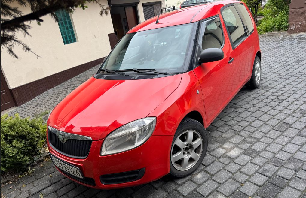 Na zdjęciu widać samochód w kolorze czerwonym kombi.