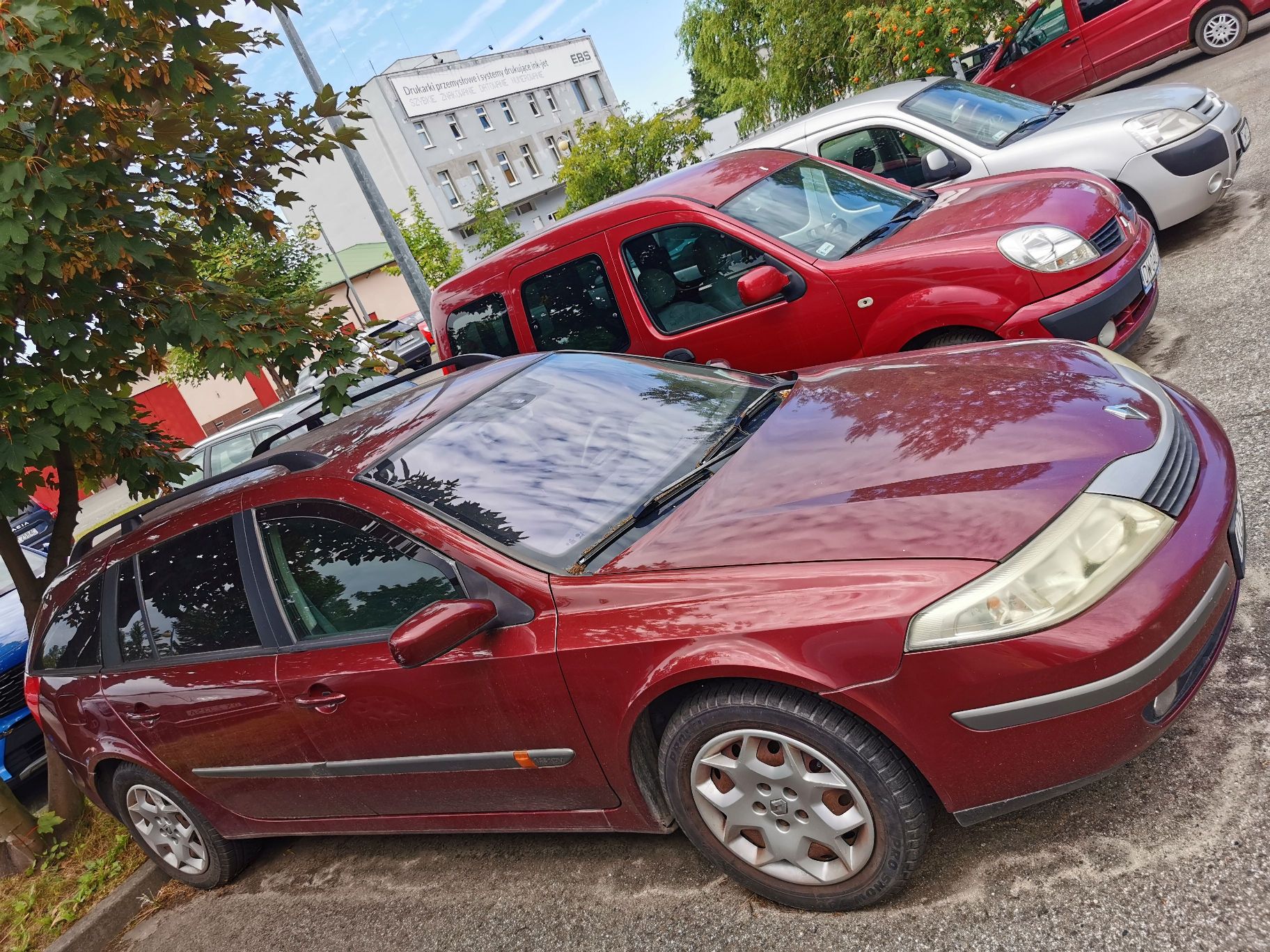Samochód osobowy marki Renault Laguna kombi rocznik 2004 , kolor bordowy, widok z prawego przodu.