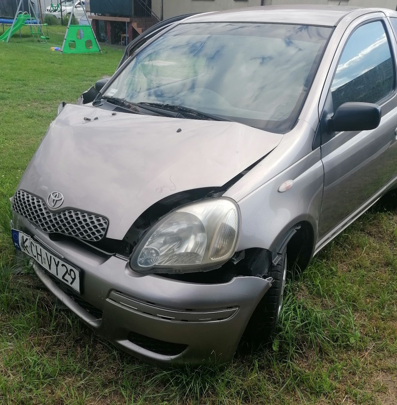 Samochód osobowy Toyota Yaris koloru srebrnego przód lewa strona.