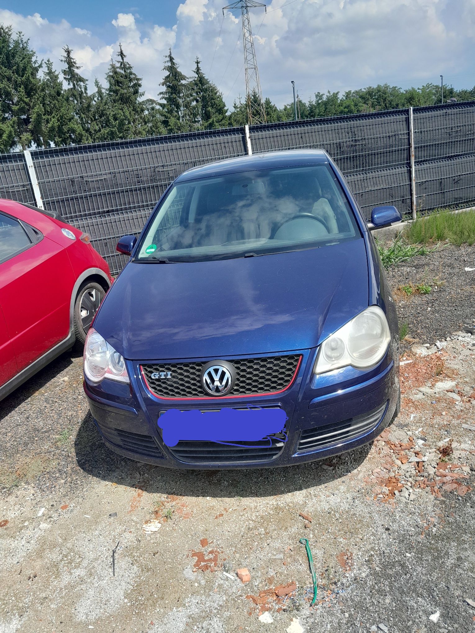 Niebieski Volkswagen Polo, widziany od przodu, bez widocznych uszkodzeń.