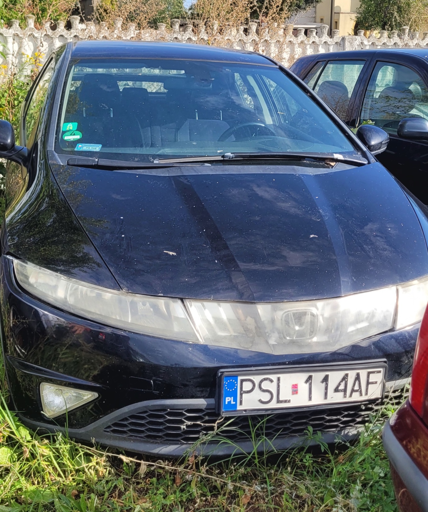 Zdjęcie przedstawia przód czarnego samochodu osobowego marki Honda Civic ósmej generacji.