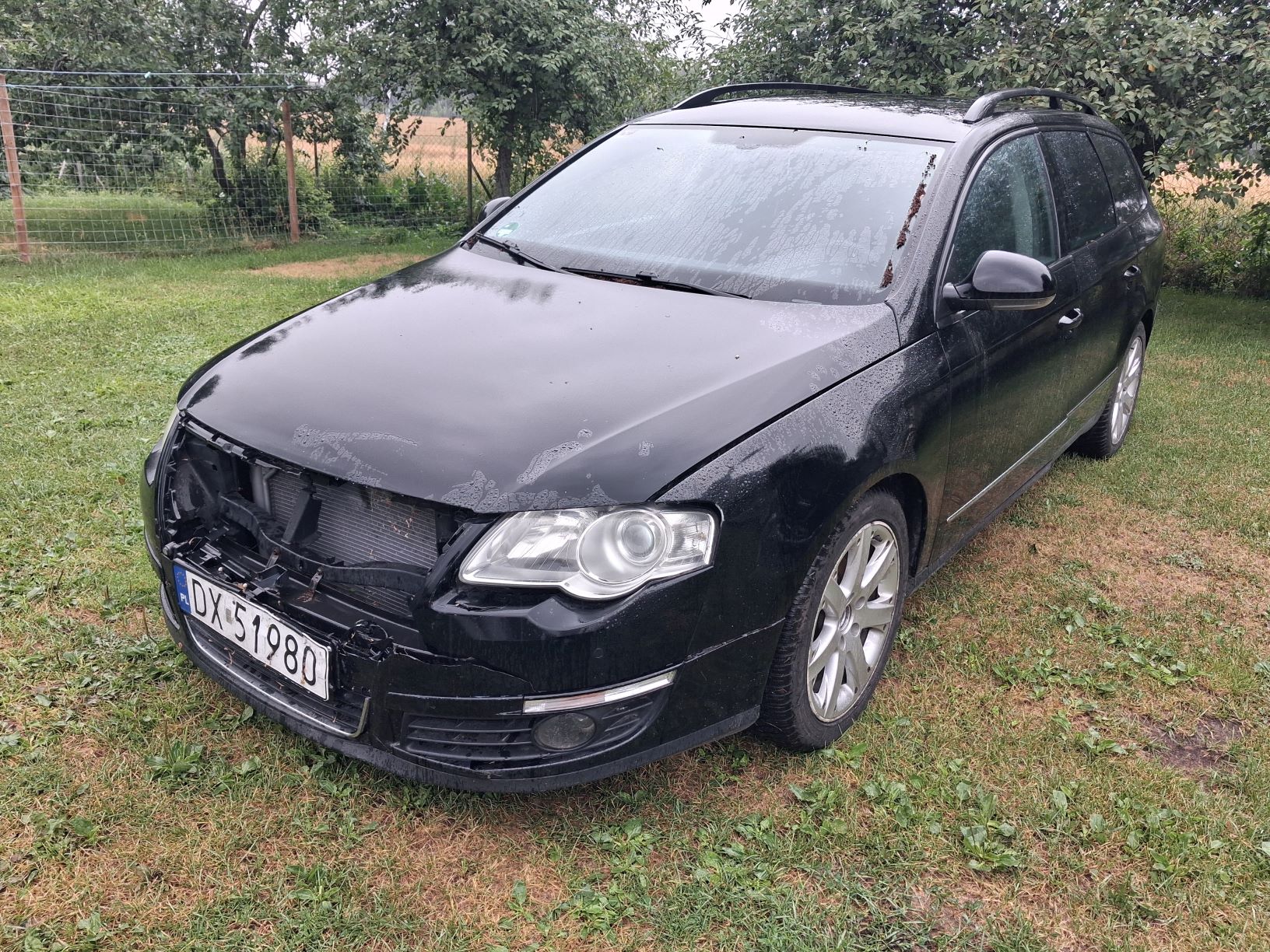 Przód czarnego samochodu z widocznym uszkodzeniem.