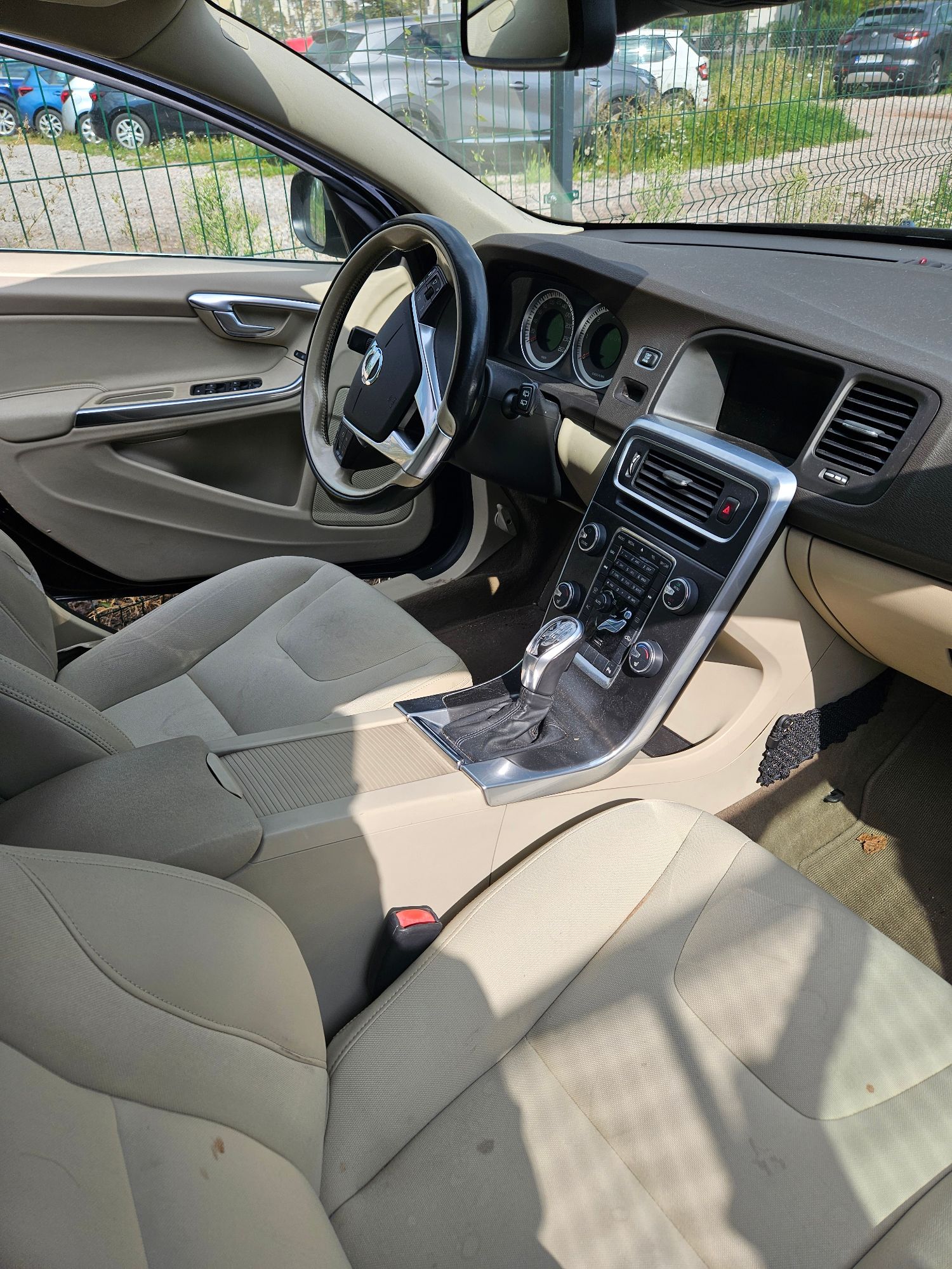 Samochód marki Volvo koloru czarnego. Widok wnętrza pojazdu na tablicę rozdzielczą z fotela pasażera.