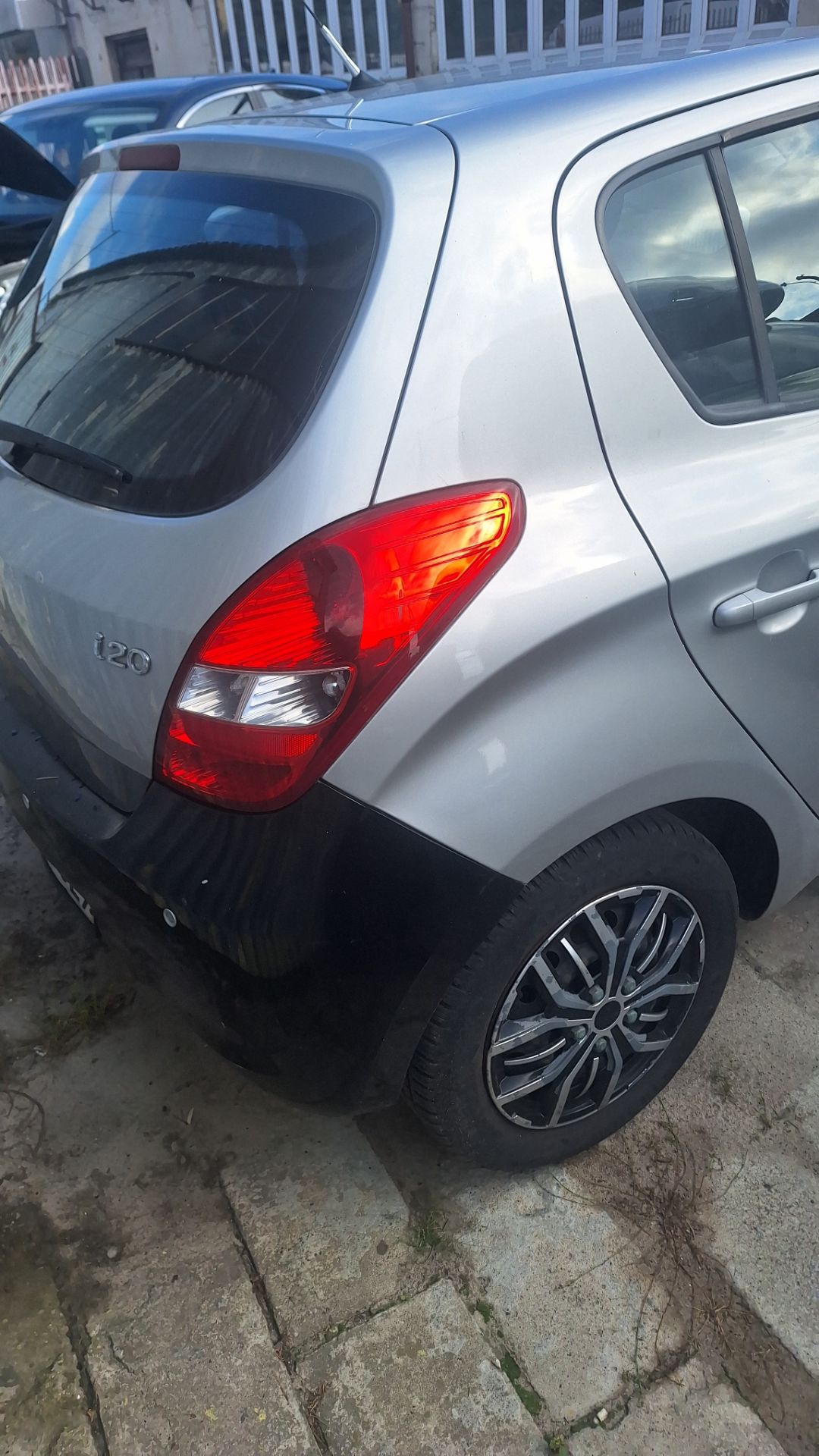Samochód Hyundai i20 w kolorze szarym widoczny od tyłu z prawej strony.