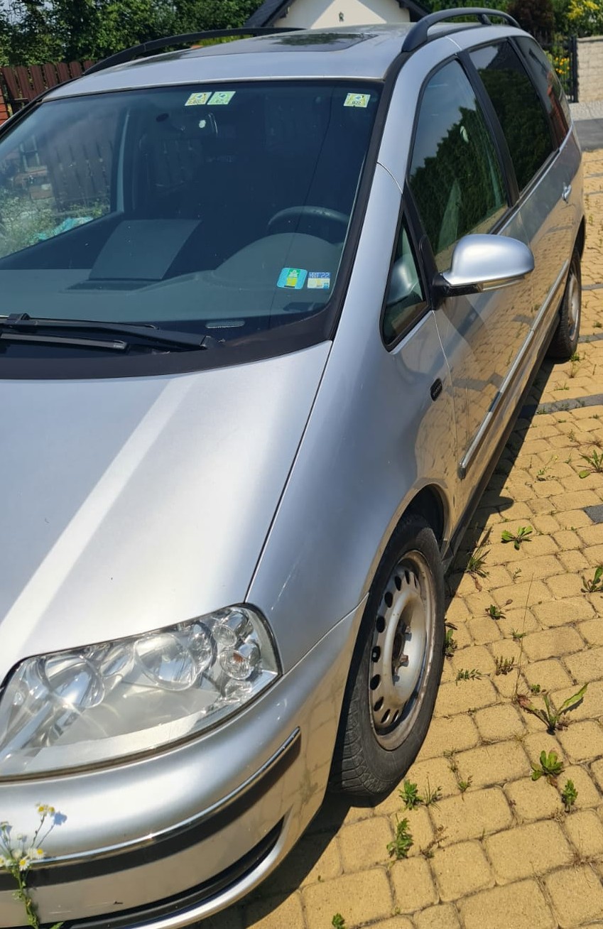 Lewy bok srebrnego samochodu marki Volkswagen Sharan.