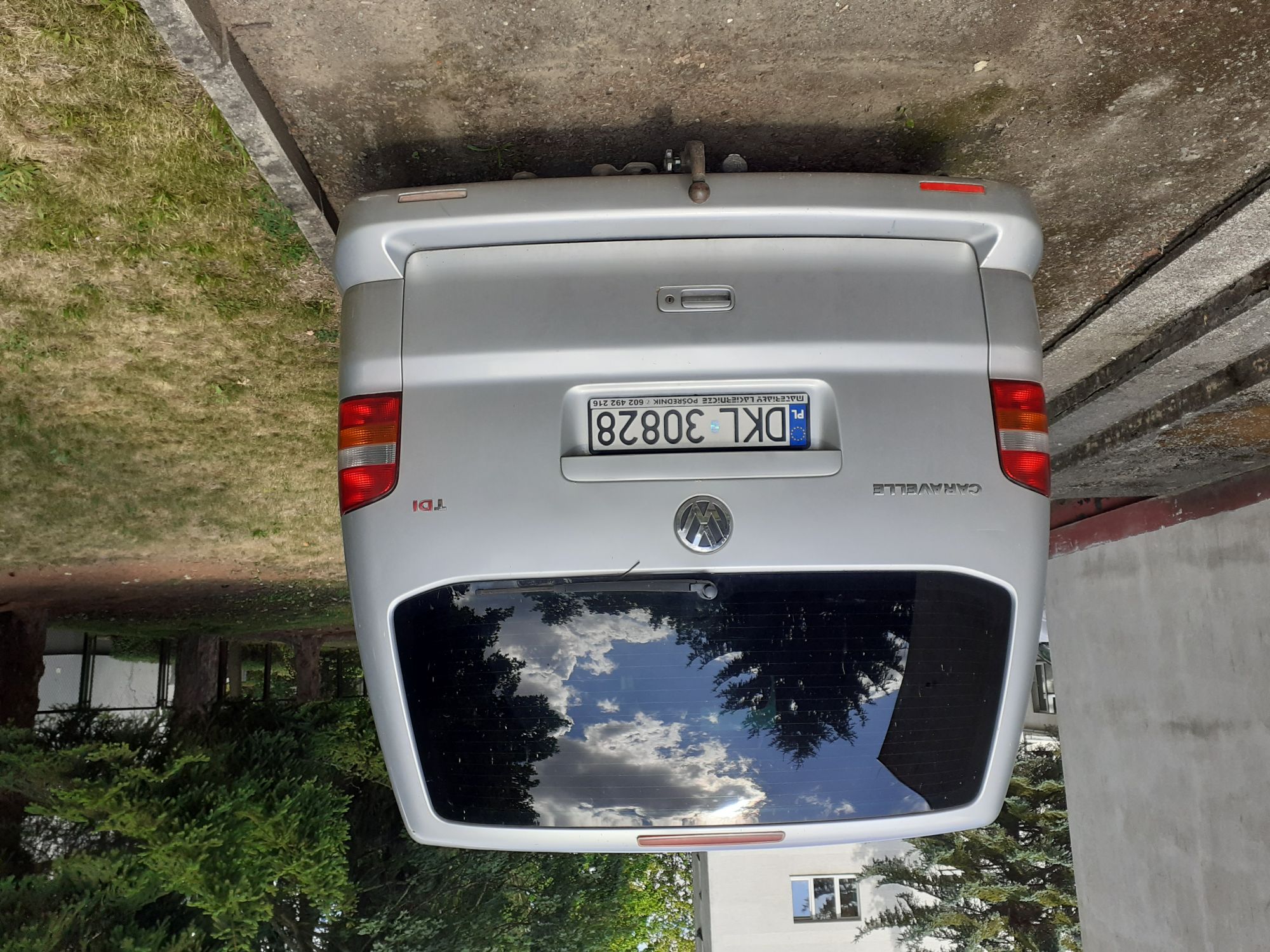Srebrny Volkswagen Caravelle zaparkowany tyłem