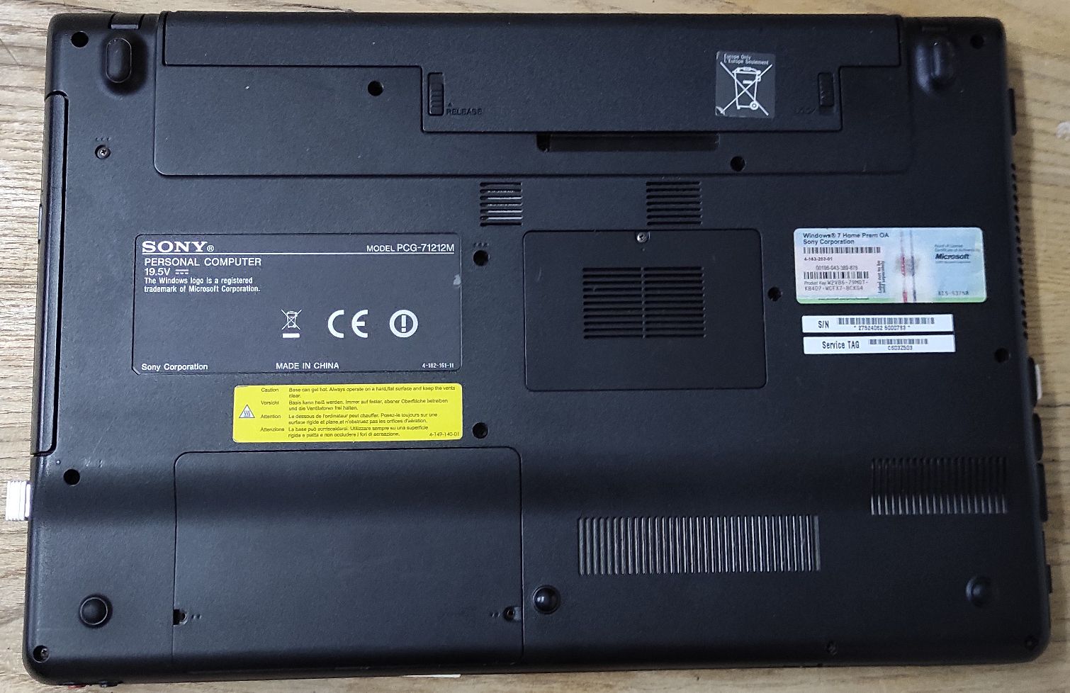Spód laptopa z widoczną tabliczką znamionową ze wskazanym modelem PCG-71212M, naklejką z numerem seryjnym 27524062 5000783.