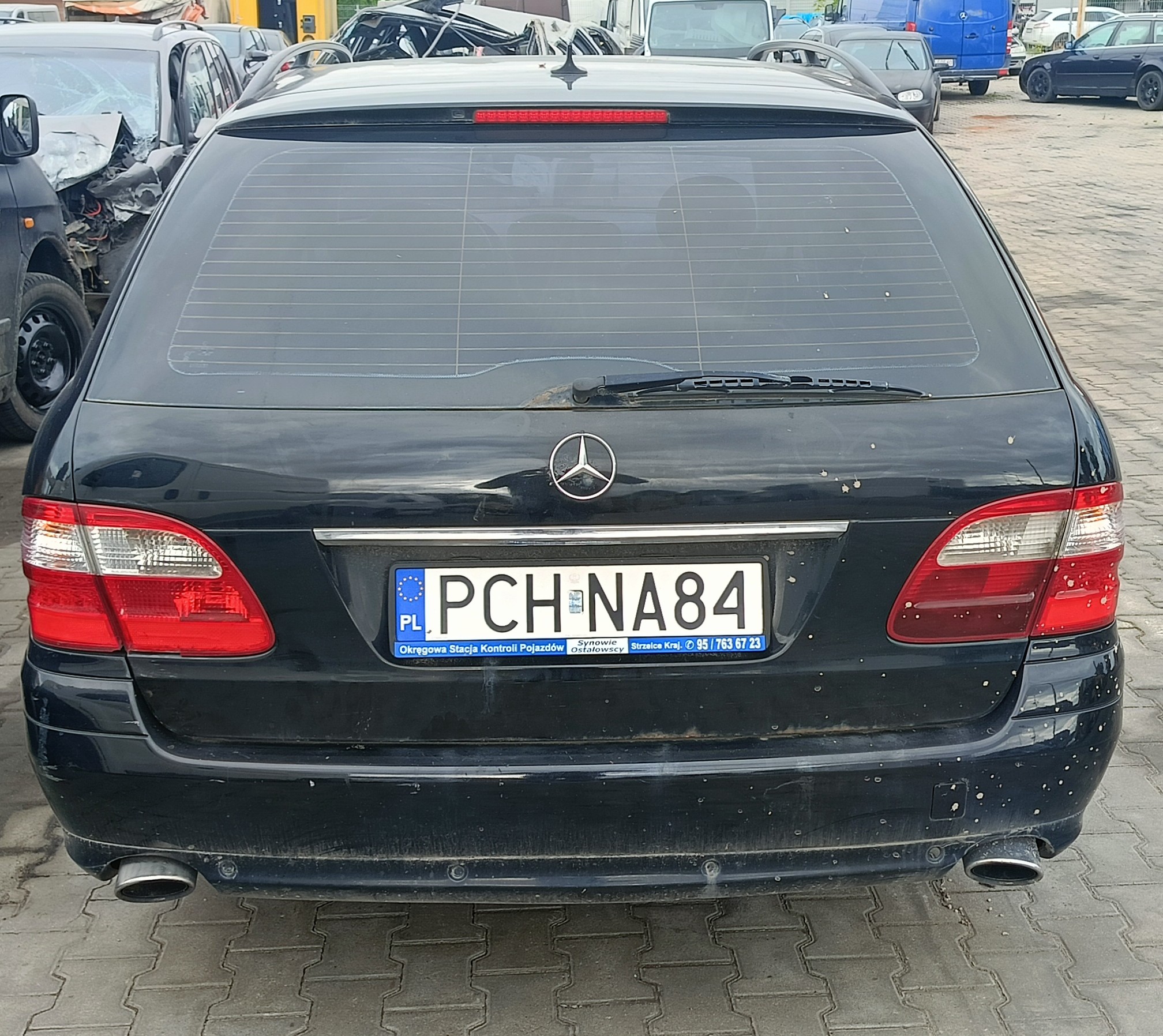 tył granatowego Mercedesa E320 CDI, z widocznymi ogniskami korozji na klapie bagażnika