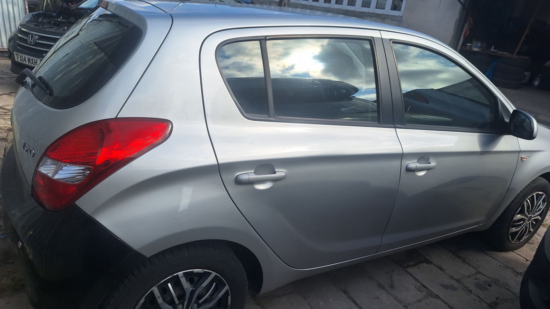 Samochód Hyundai i20 w kolorze szarym widoczny od tyłu z prawej strony.