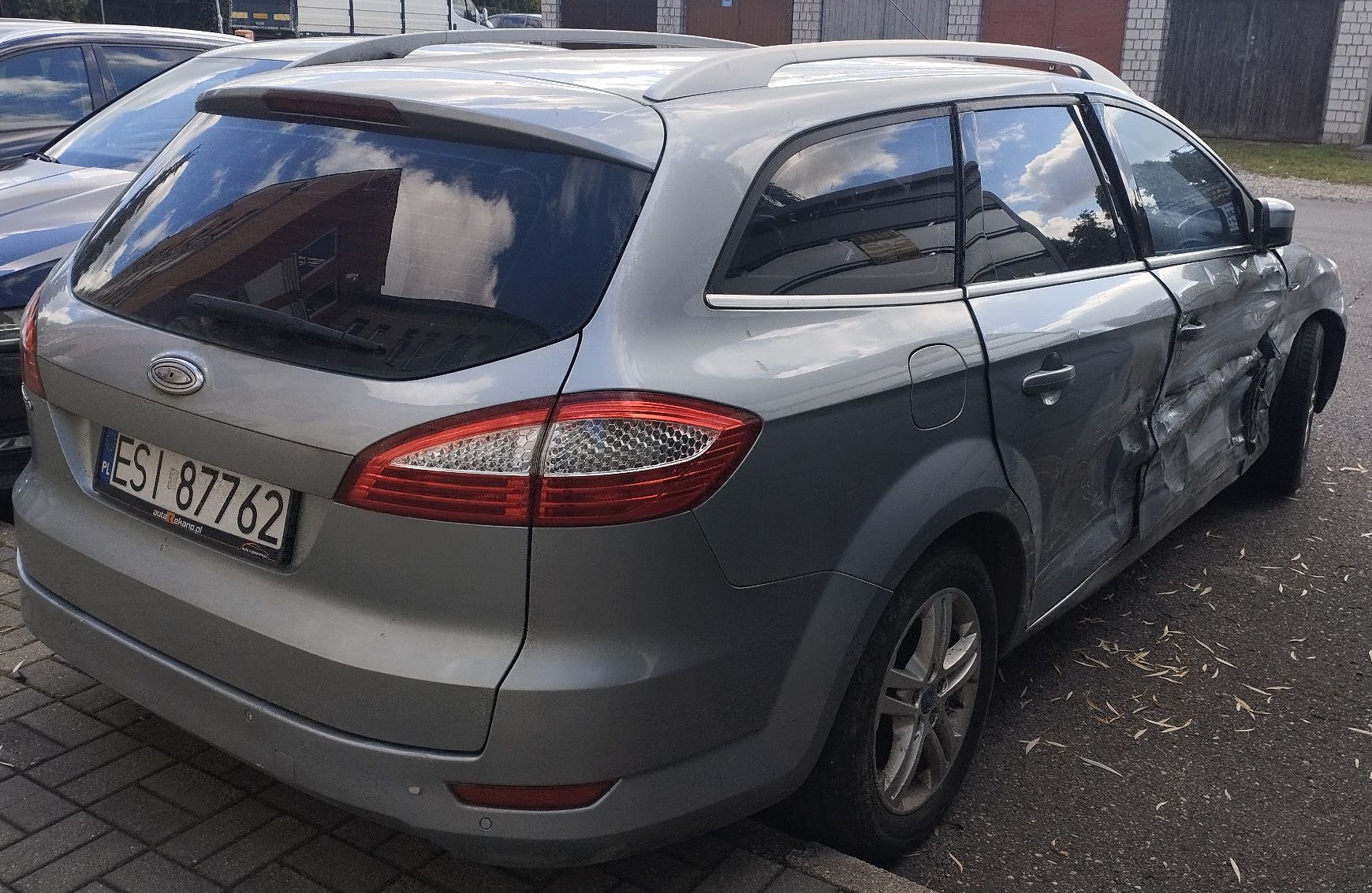 Srebrny Ford Mondeo kombi z widocznymi mocnymi wgnieceniami i uszkodzeniami całego prawego boku.