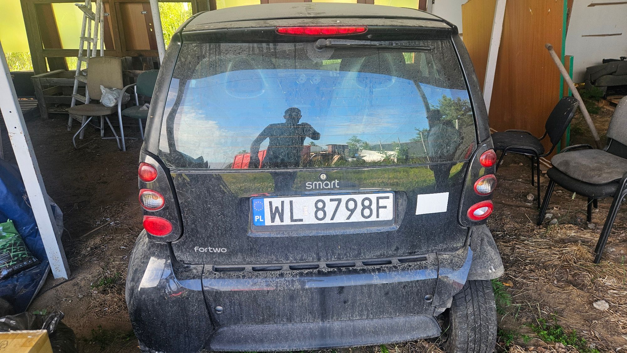 Na zdjęciu czarny Smart z widocznym uszkodzniem