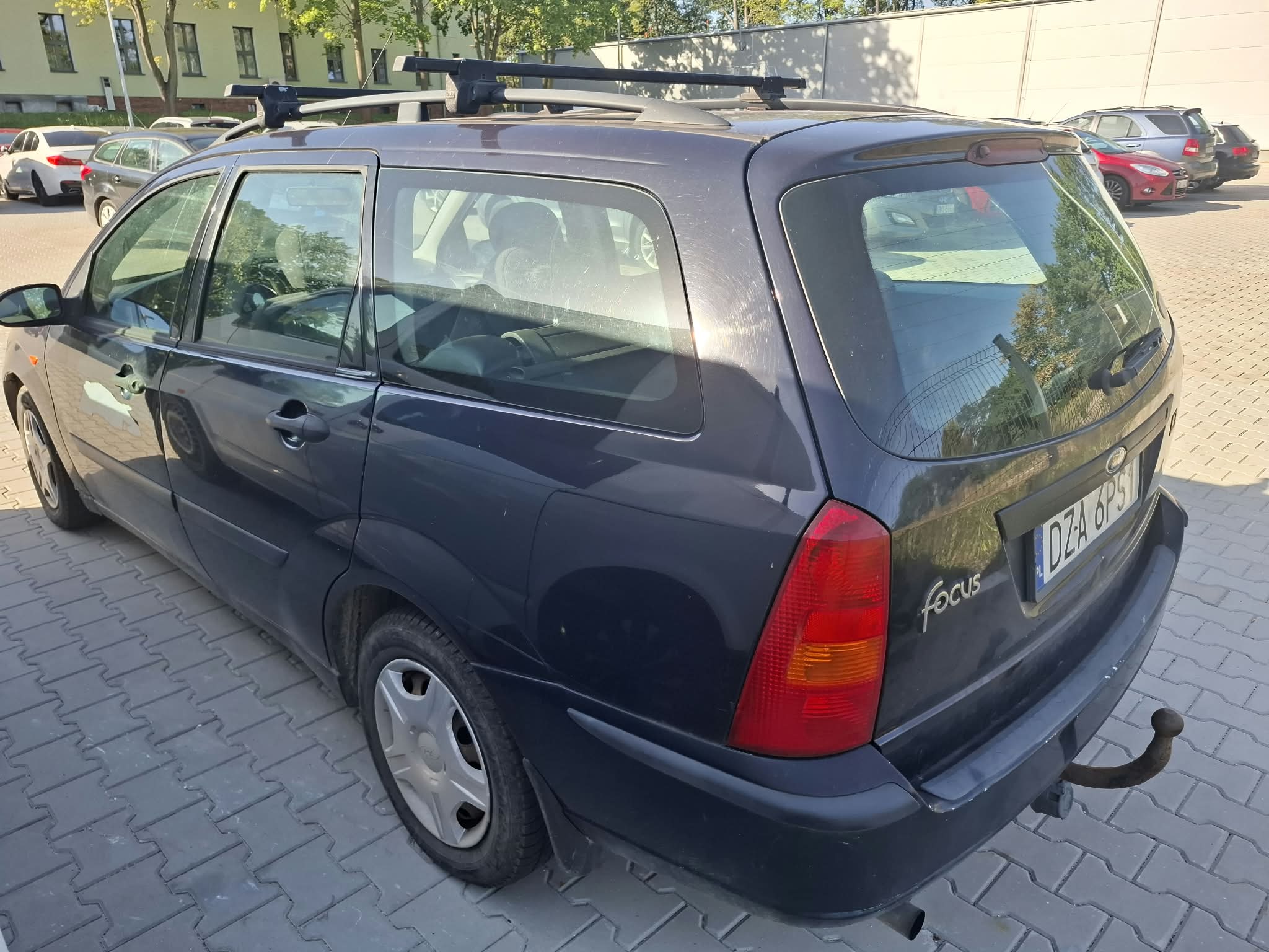Widok tyłu oraz lewego boku granatowego samochodu ford focus.