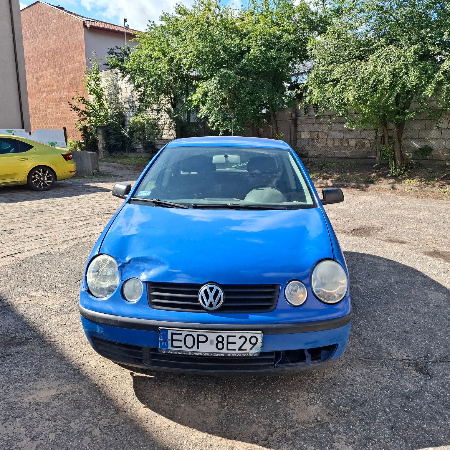 Zdjęcie pojazdu od przodu z widocznym uszkodzeniem maski.