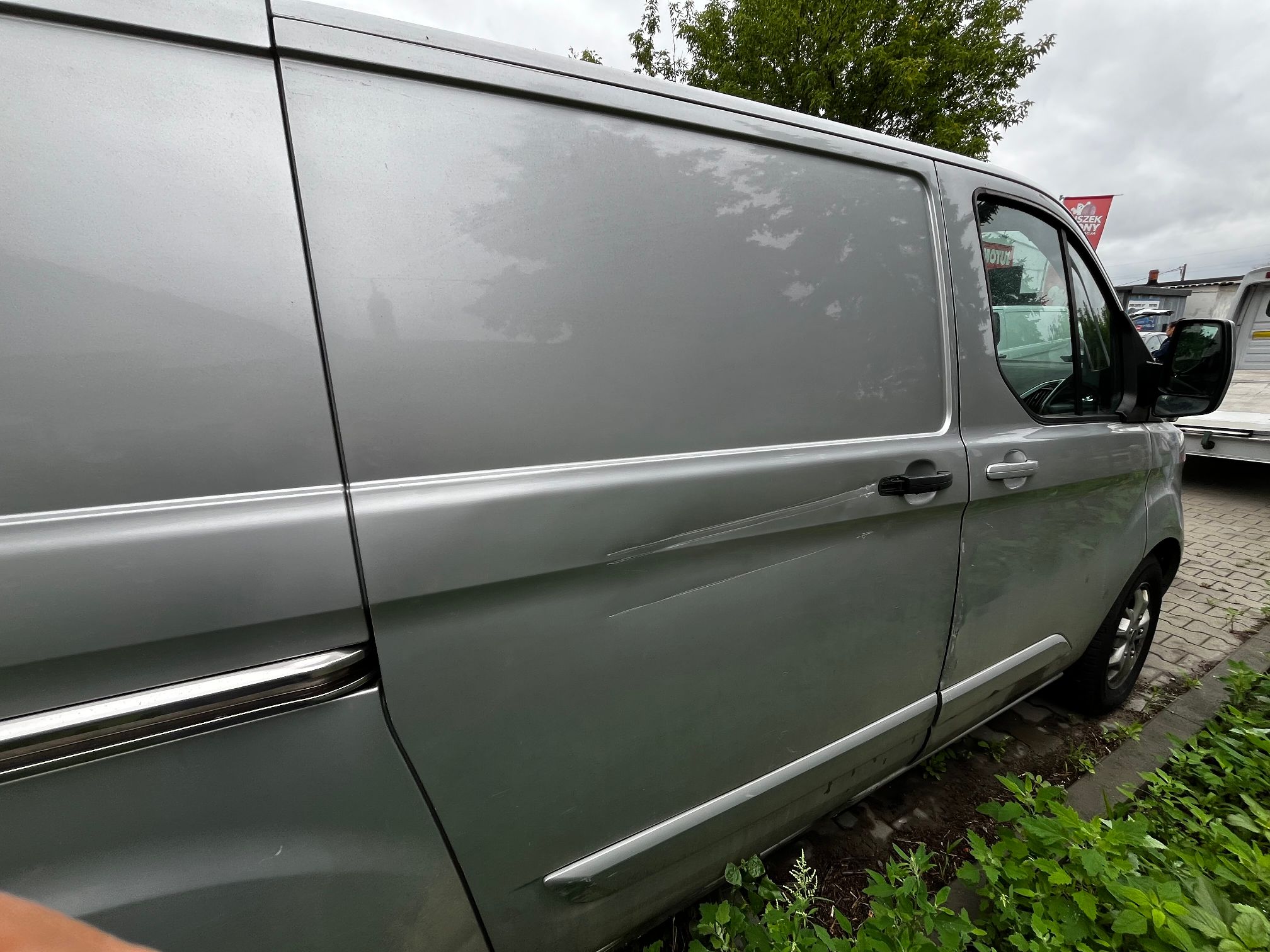 srebrny ford transit custom widoczna strona pasażera na karoserii widać zarysowania