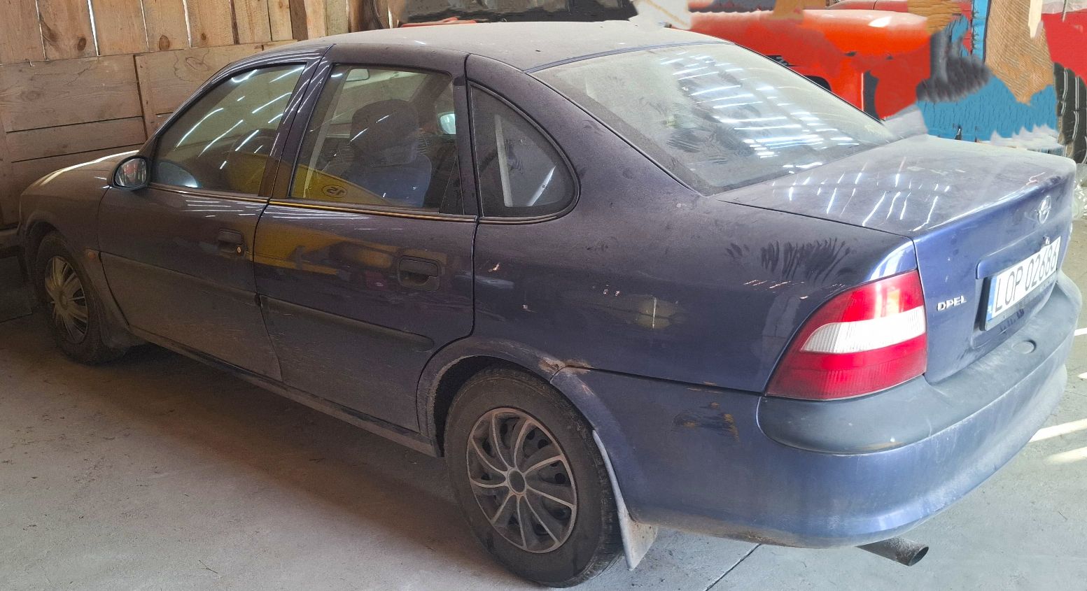 granatowy Opel Vectra w wersji sedan, 5 drzwiowy, wyprodukowany w 1997 r.