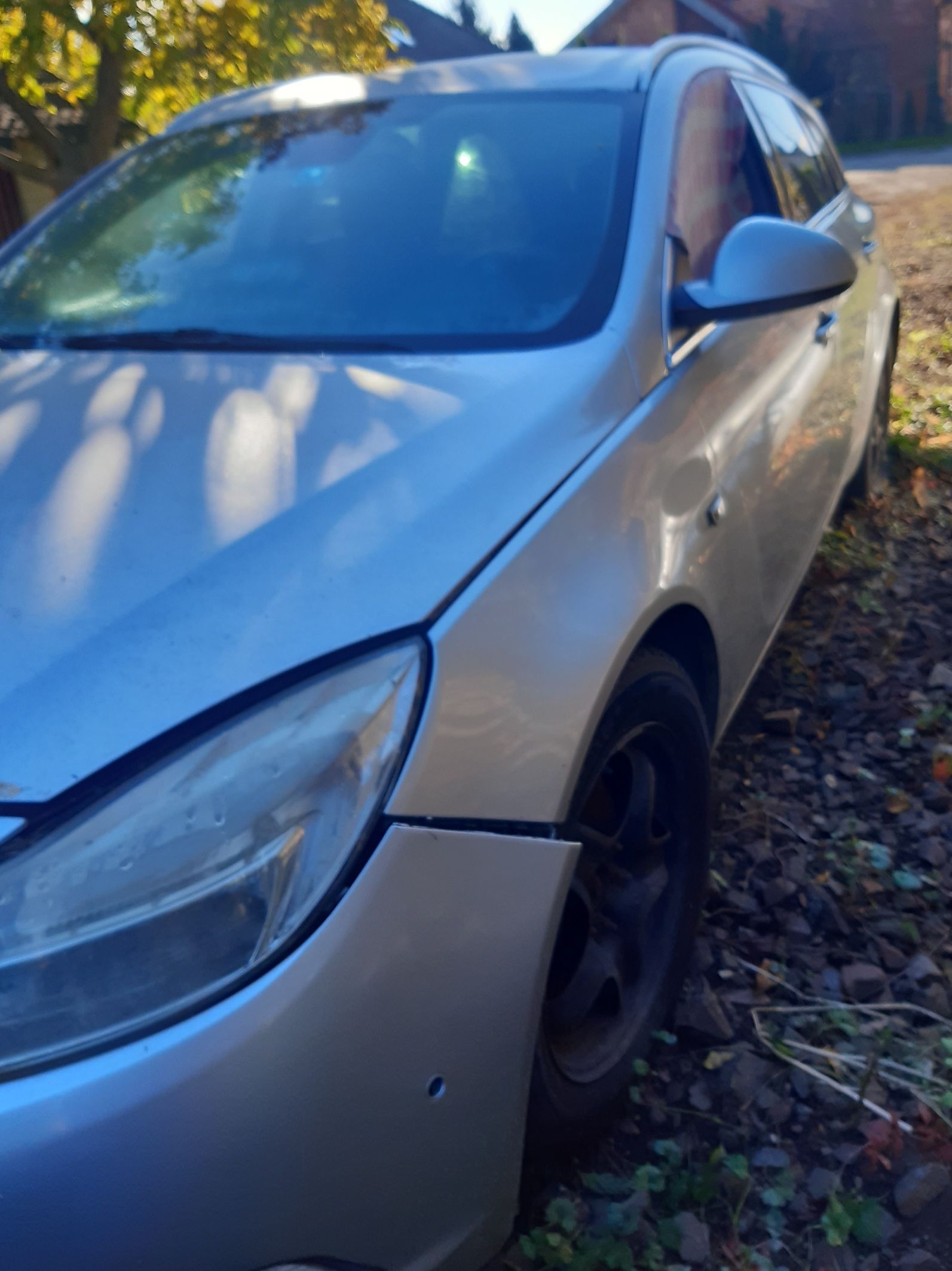 Srebrny Opel Insignia kombi, widok z przodu od boku; widoczna lekka szczelina między zderzakiem a przednim błotnikiem.