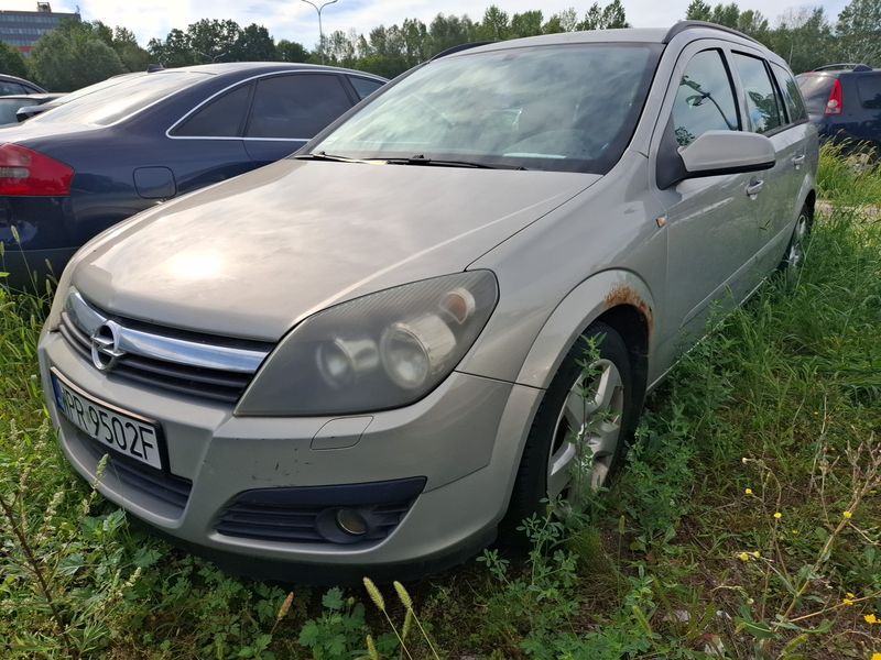 Srebrny samochód osobowy typu kombi Opel Astra.