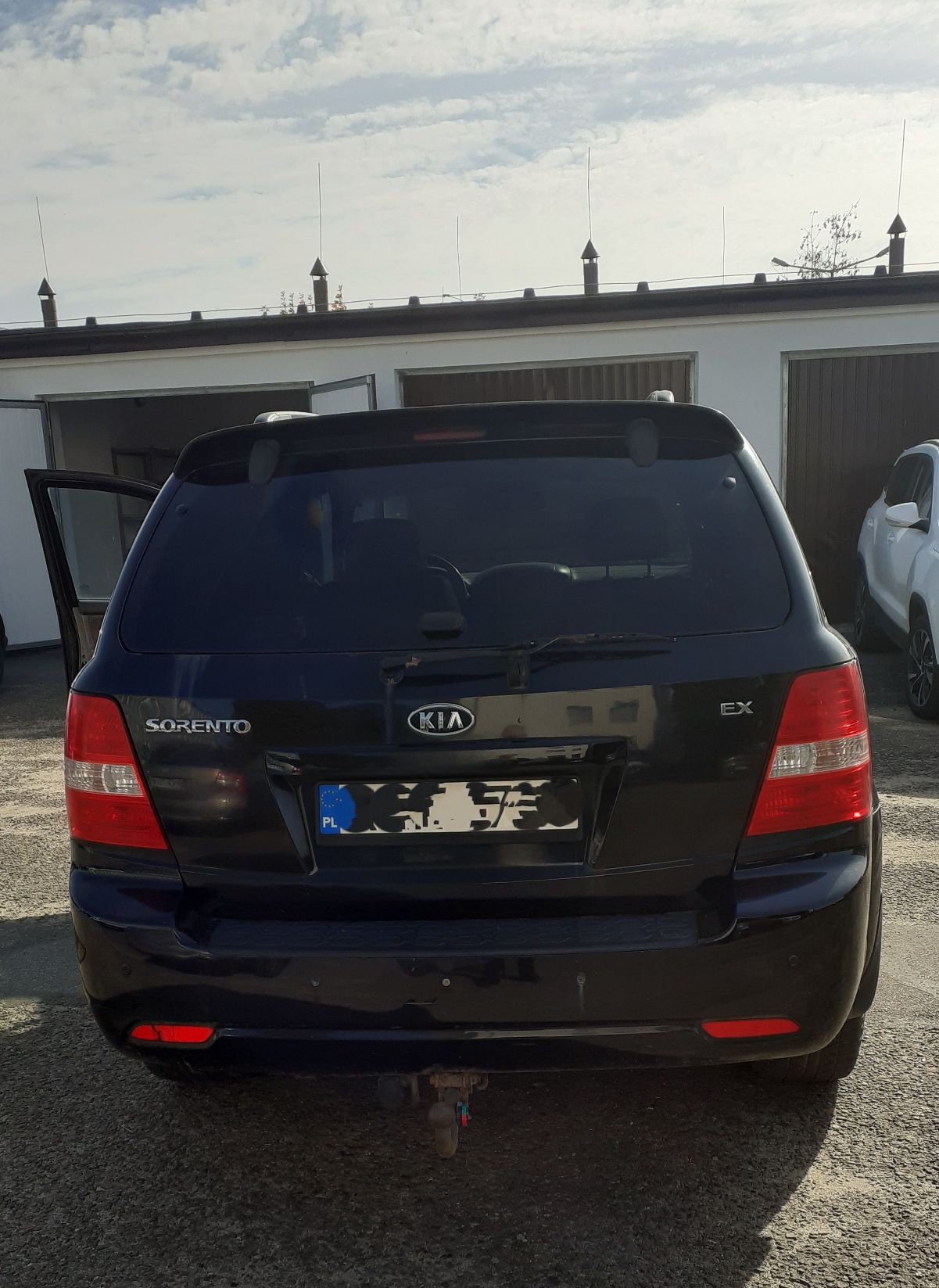 Tył czarnego SUV-a Kia Sorento, widoczna przyciemniona szyba oraz hak holowniczy.