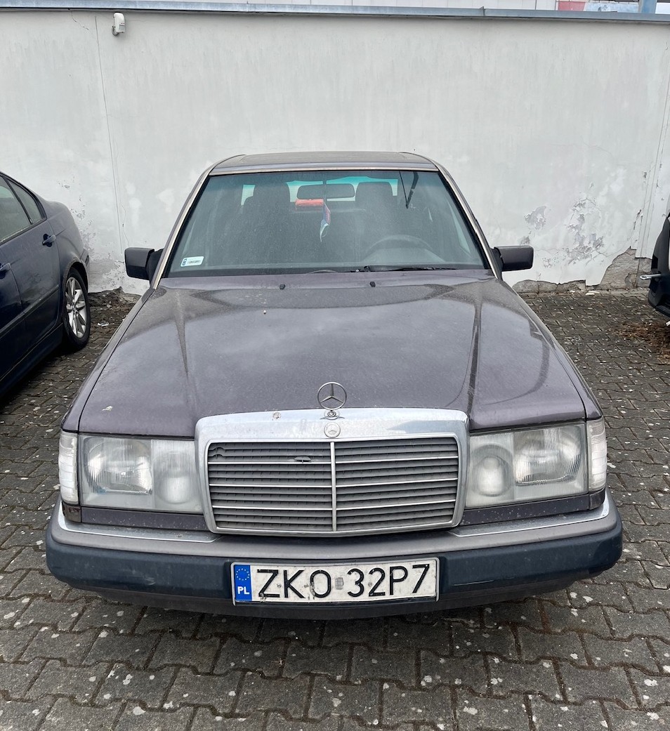 Widok na Mercedesa W124 z przodu od strony kierowcy.