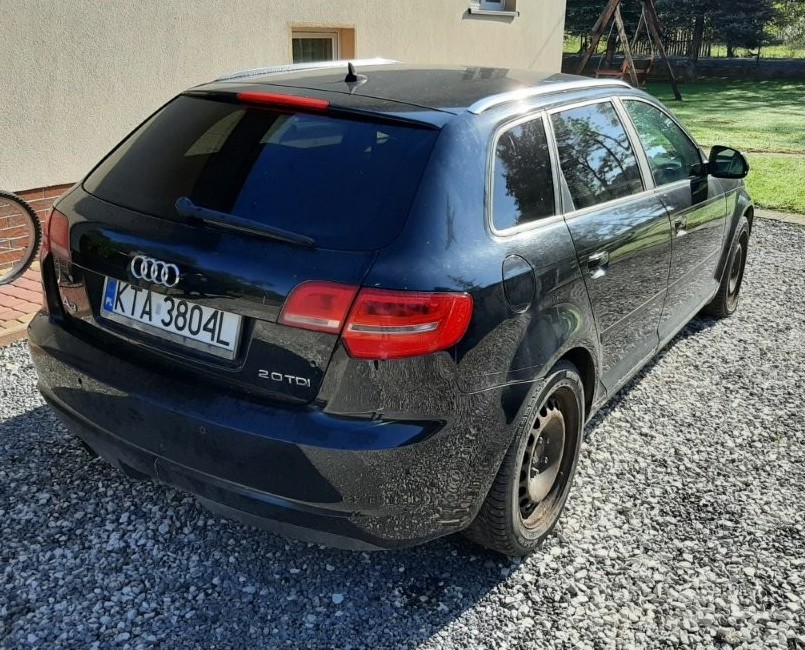 Prawy bok i tył czarnego hatchback Audi A3. Widoczne pięciodrzwiowe nadwozie, czarne felgi stalowe oraz logo na klapie.