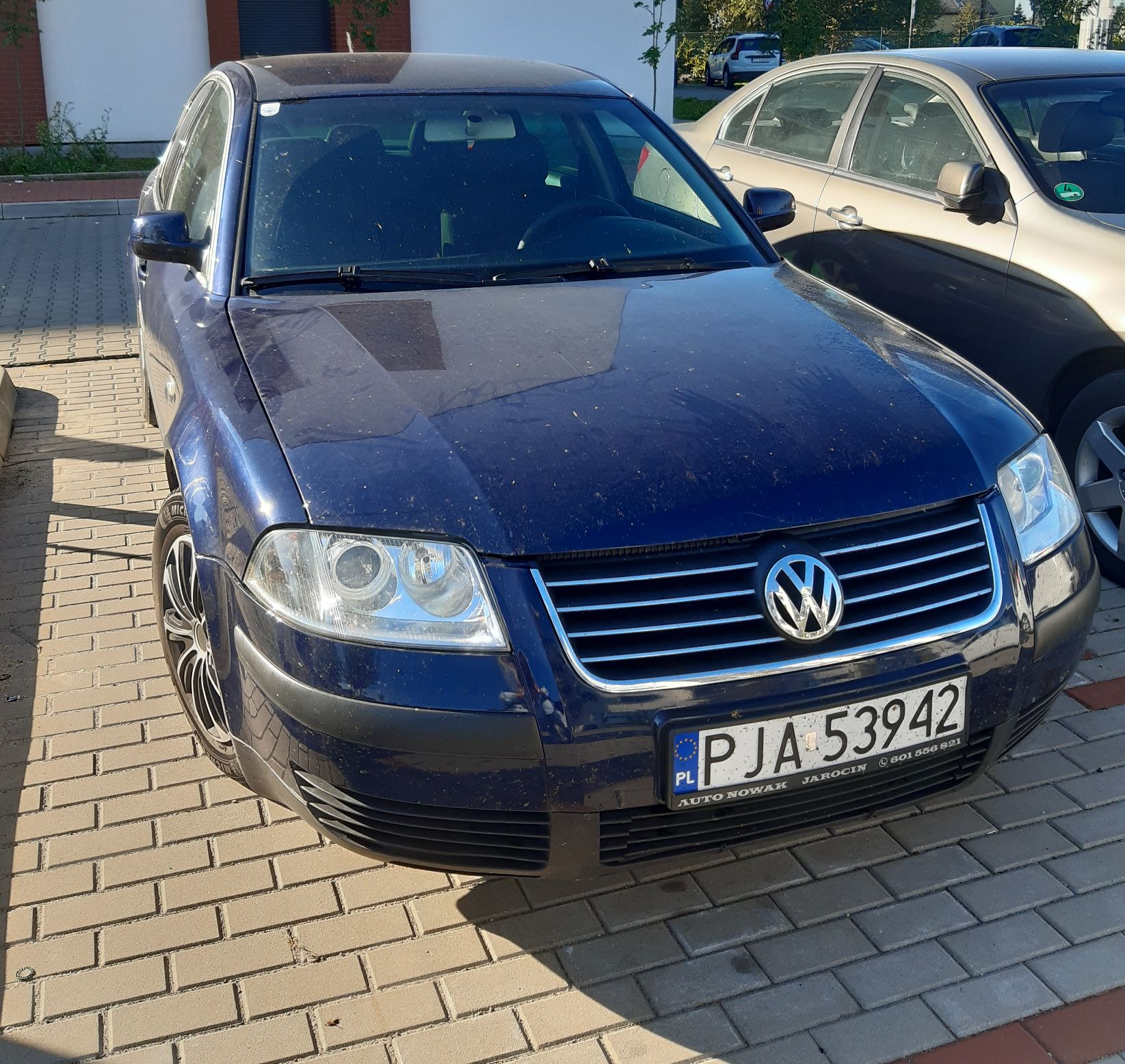 ciemnoniebieski samochód osobowy marki Volkswagen Passat z widoczną polską tablicą rejestracyjną.
