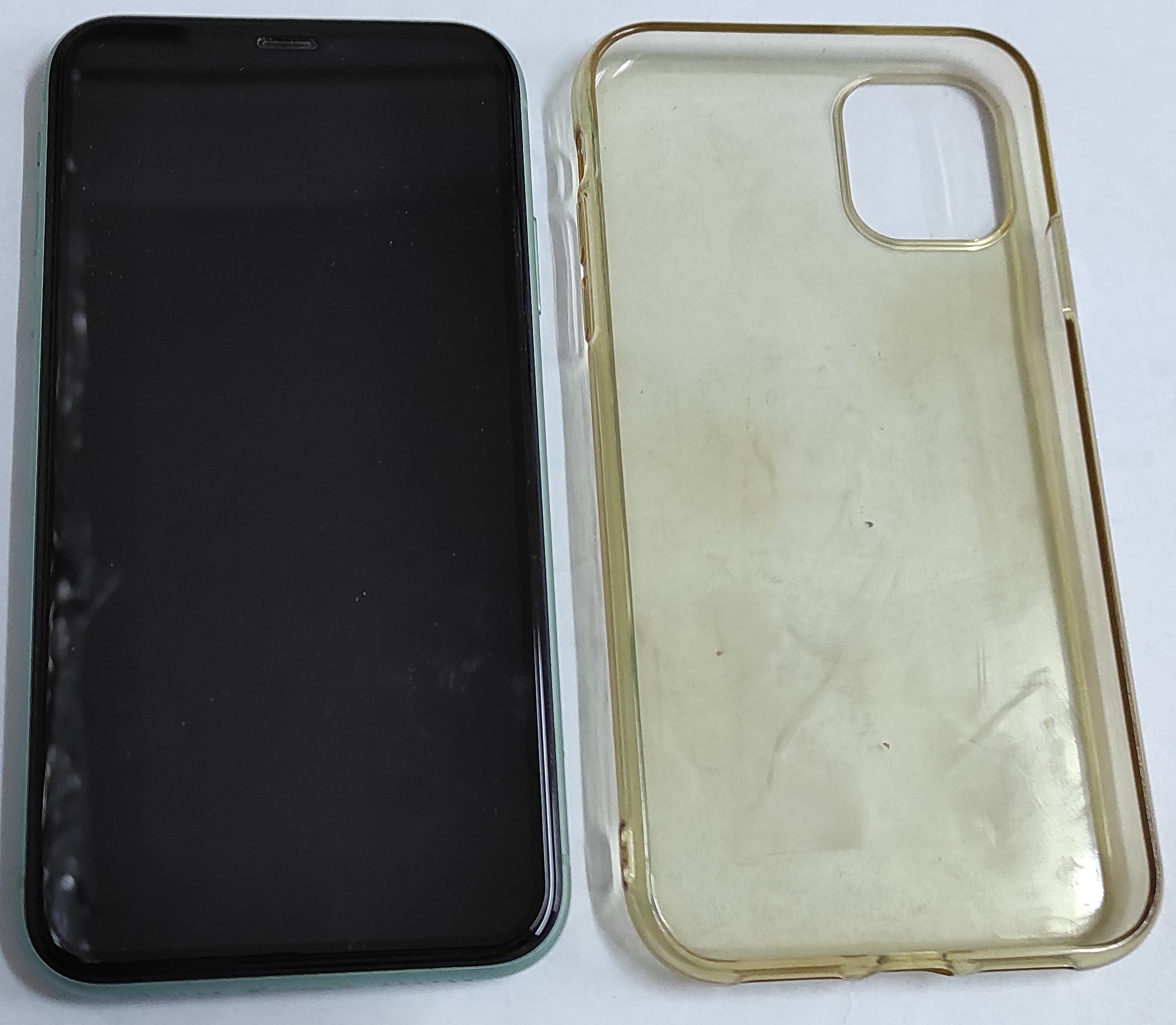 Telefon iPhone 11 z leżącym obok przeźroczystym etui