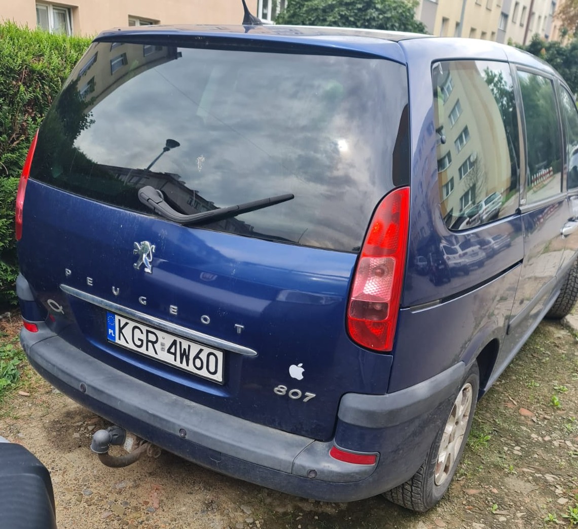 Granatowy samochód Peugeot 807 z tylną wycieraczką i tablicą rejestracyjną z Polski.