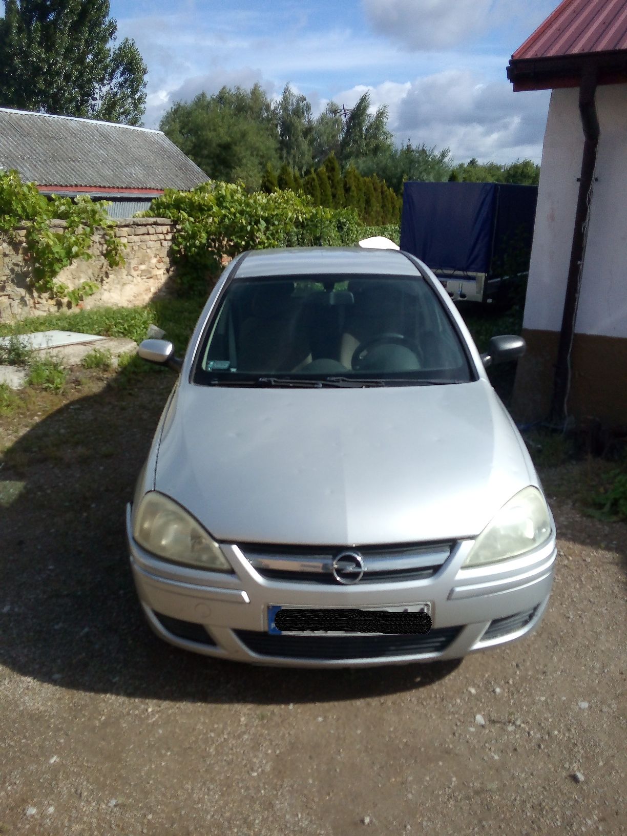 Srebrny samochód osobowy marki Opel Corsa widziany z przodu, na karoserii widoczne wgniecenia po gradobiciu
