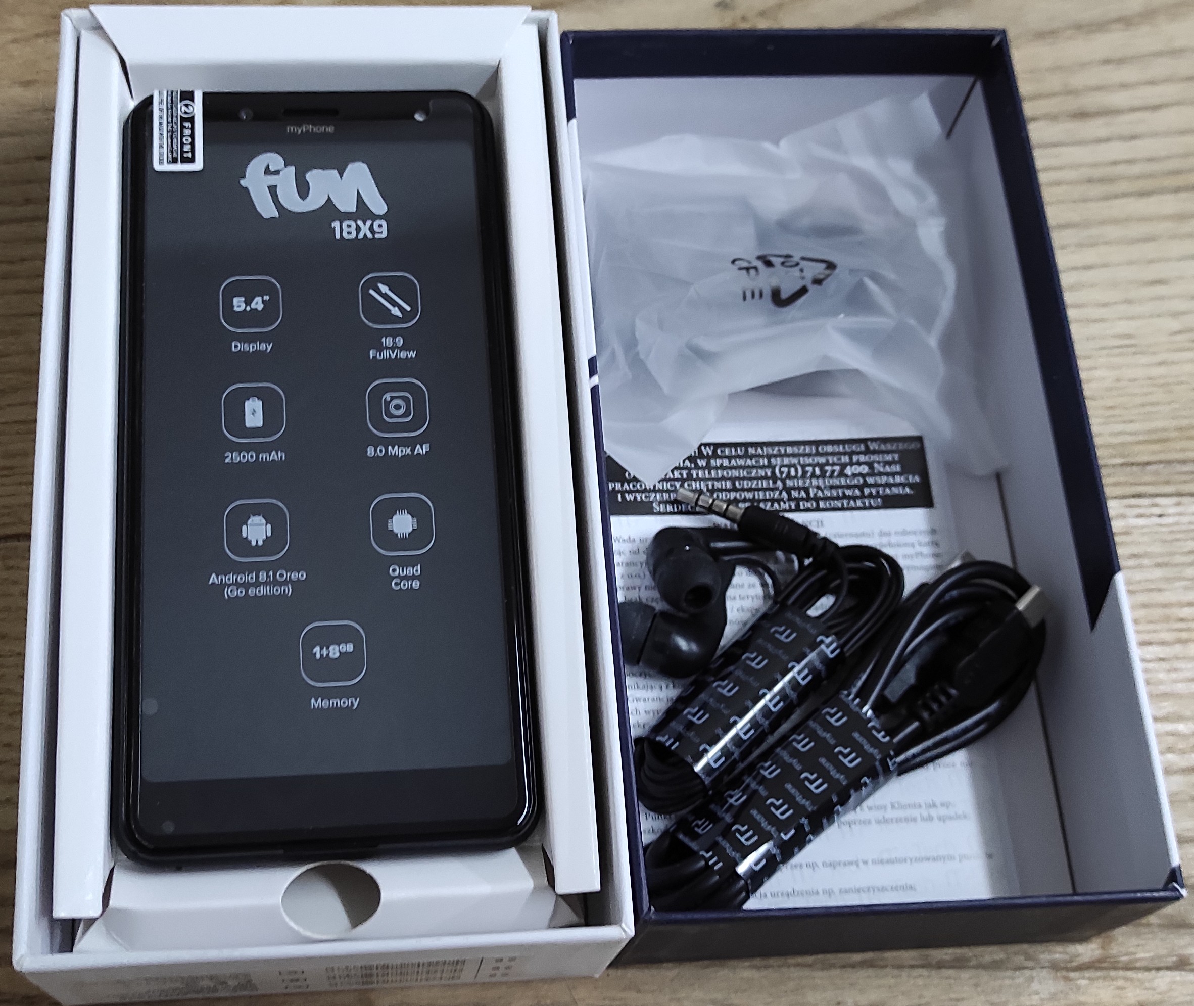 Zestaw telefon, słuchawki, ładowarka w pudełku.