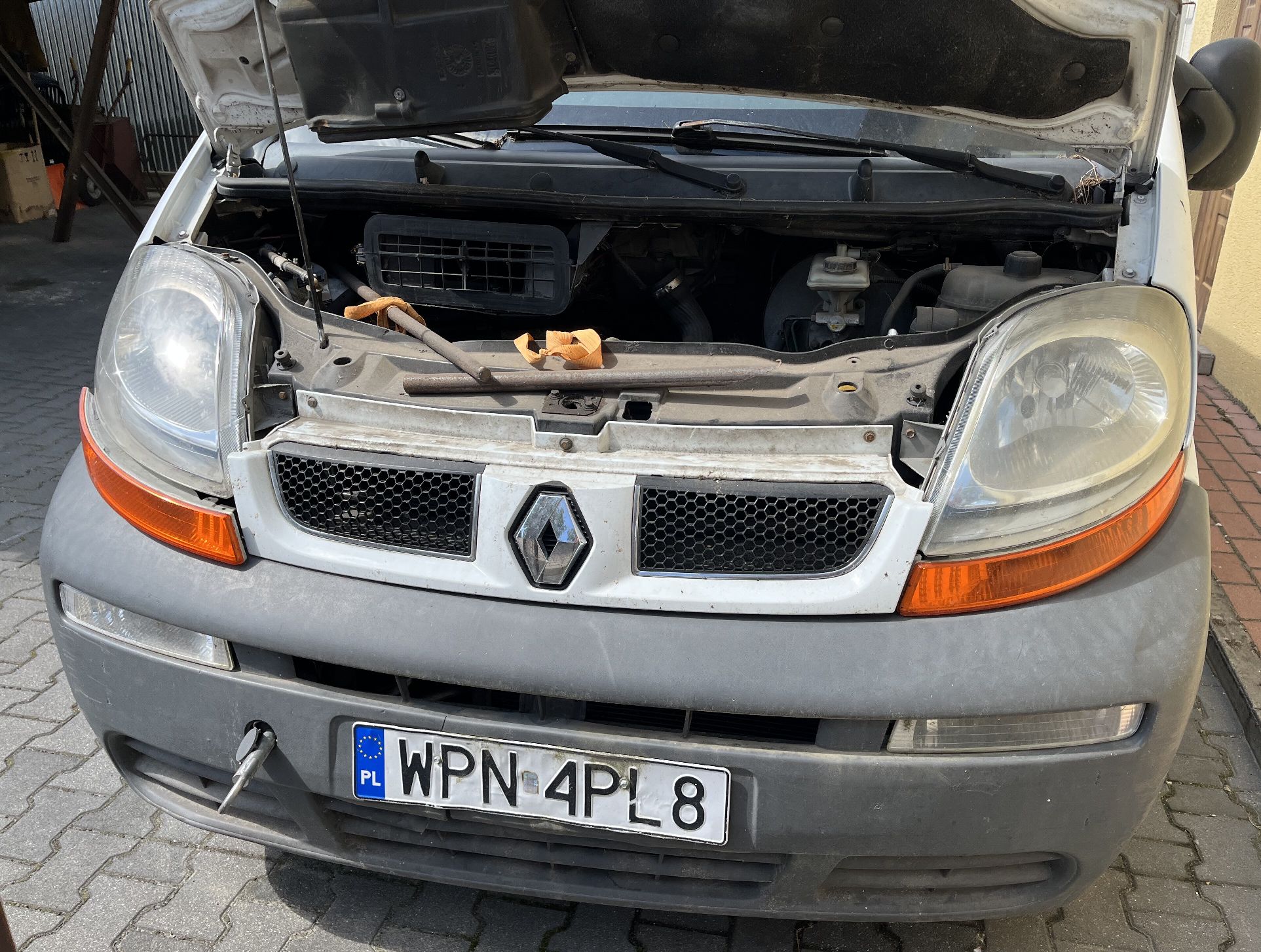 Komora silnika, zabrudzona, silnik podwieszony na pasie transportowym.