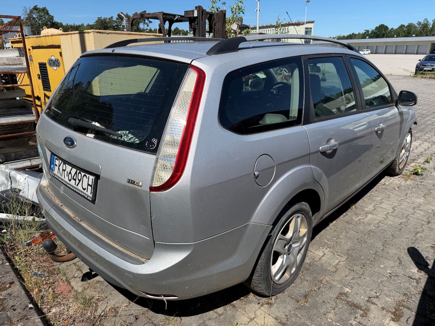 Srebrny Ford Focus, widok z tyłu prawego boku, widoczne wgniecenia na tylnej klapie bagażnika