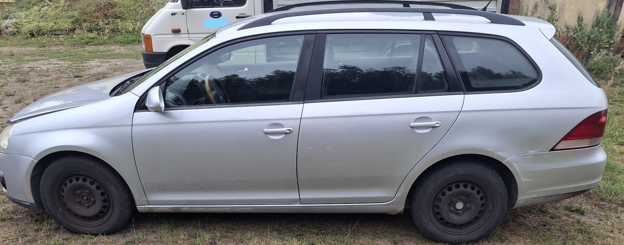 Srebrny Volkswagen Golf kombi, lewy bok auta na czarnych felgach.