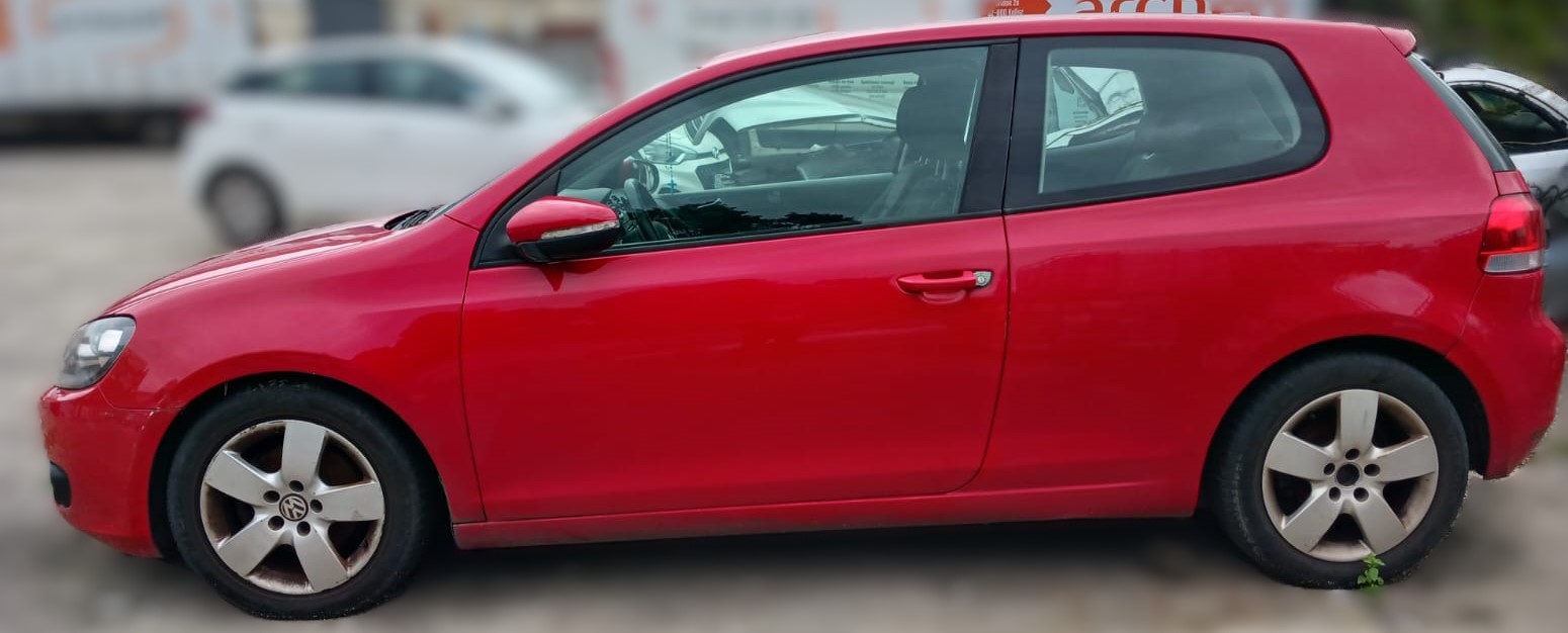 Lewy bok czerwonego Volkswagena Golfa bez widocznych uszkodzeń