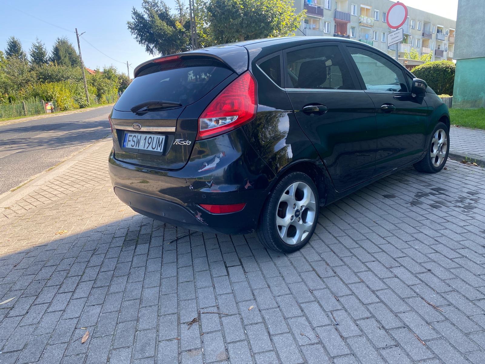 Prawa strona Forda Fiesty koloru czarnego. Felgi aluminiowe 4 ramienne 15 calowe.