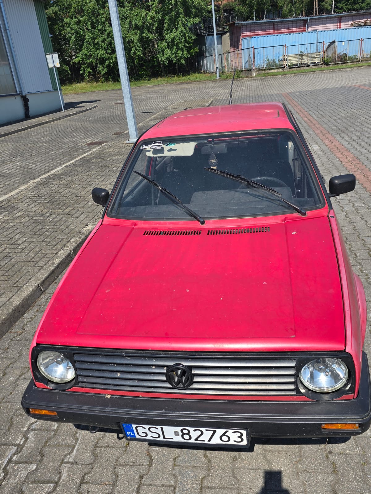 Zdjęcie przodu samochodu, kolor czerwony, odpryski na masce