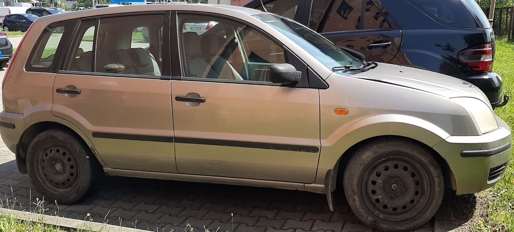 Samochód widoczny od prawego boku. Samochód na czarnych, stalowych felgach bez kołpaków.