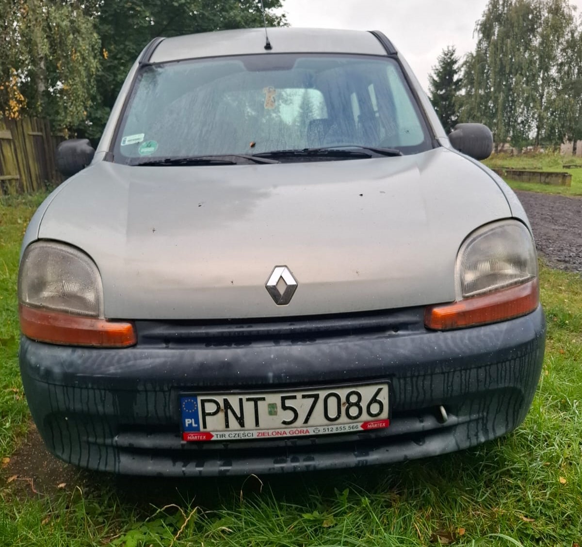 Przód szarego Renault Kangoo z widocznymi uszkodzeniami powłoki lakierniczej na masce