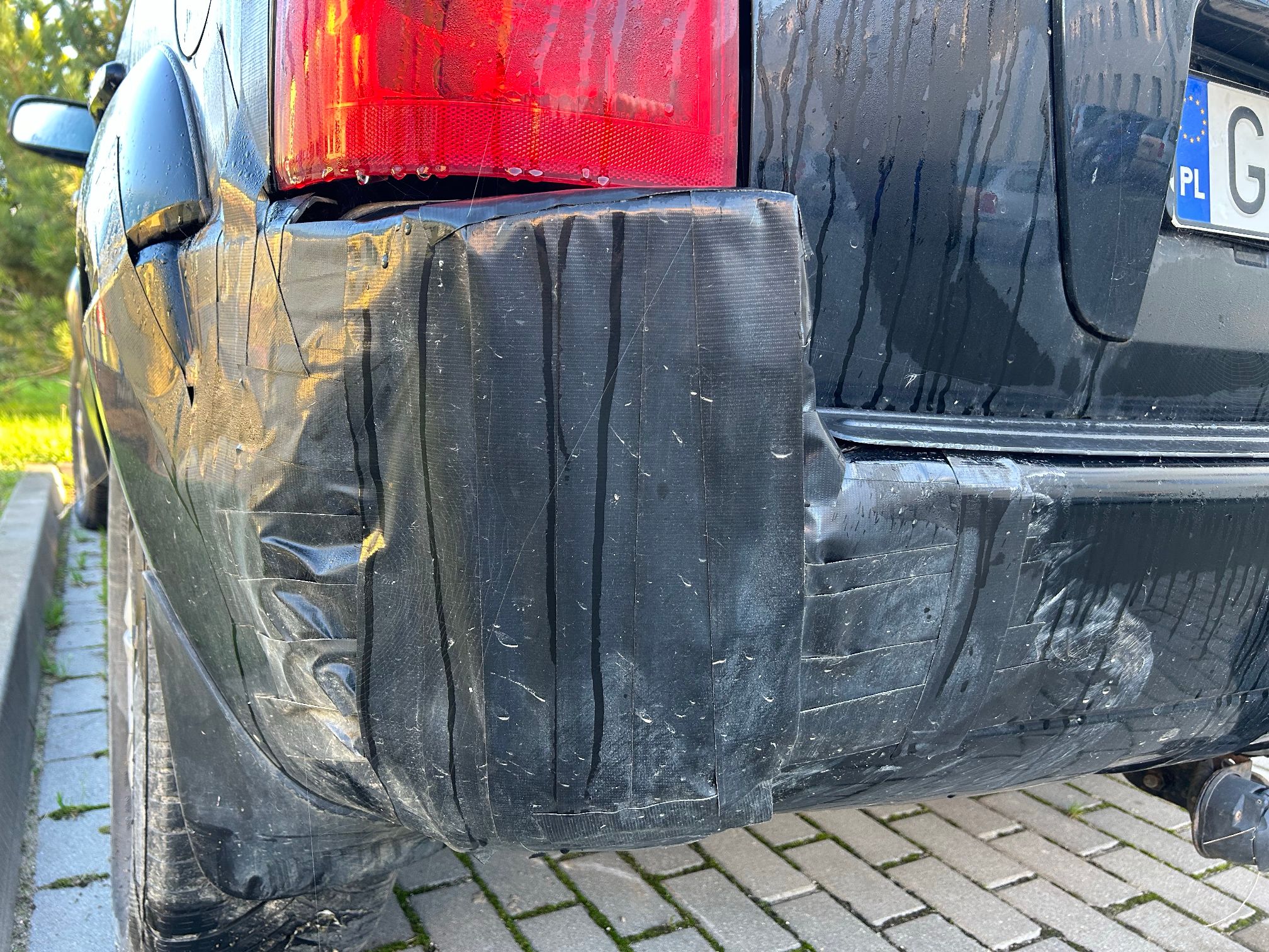 Lewa część tylnego zderzaka, oklejona czarną taśmą.