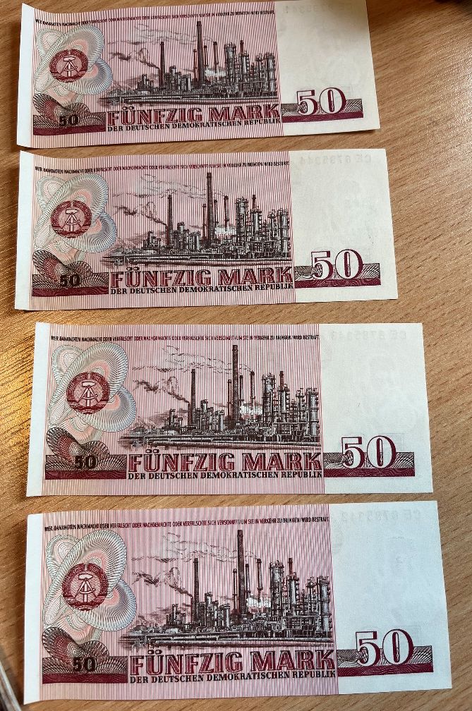 Odwrotna strona czterech banknotów o nominale 50 marek NRD z widocznym motywem fabryki.