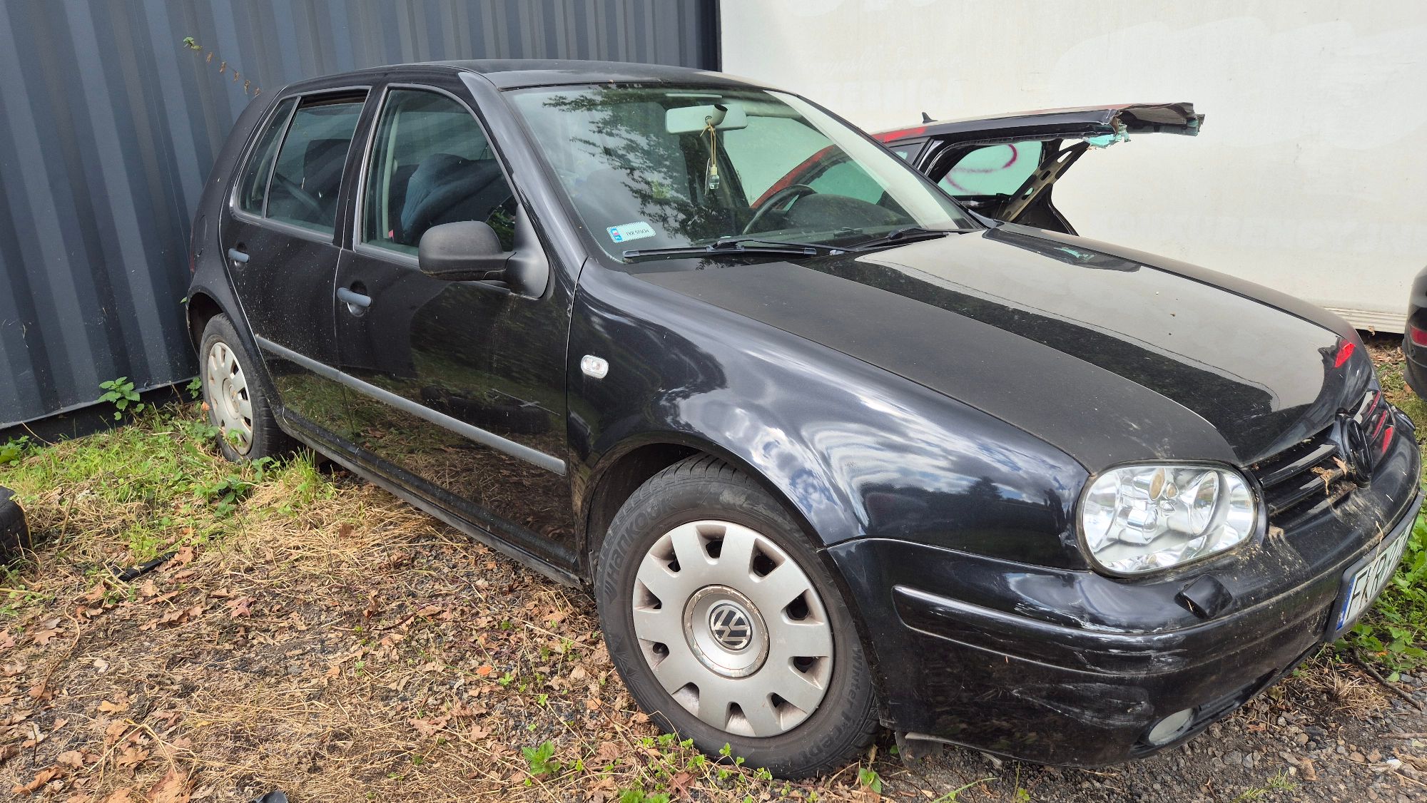 Przód i prawy bok pojazdu Volkswagen Golf, kolor czarny, szyby bez uszkodzeń, widoczne obtarcia lakieru.