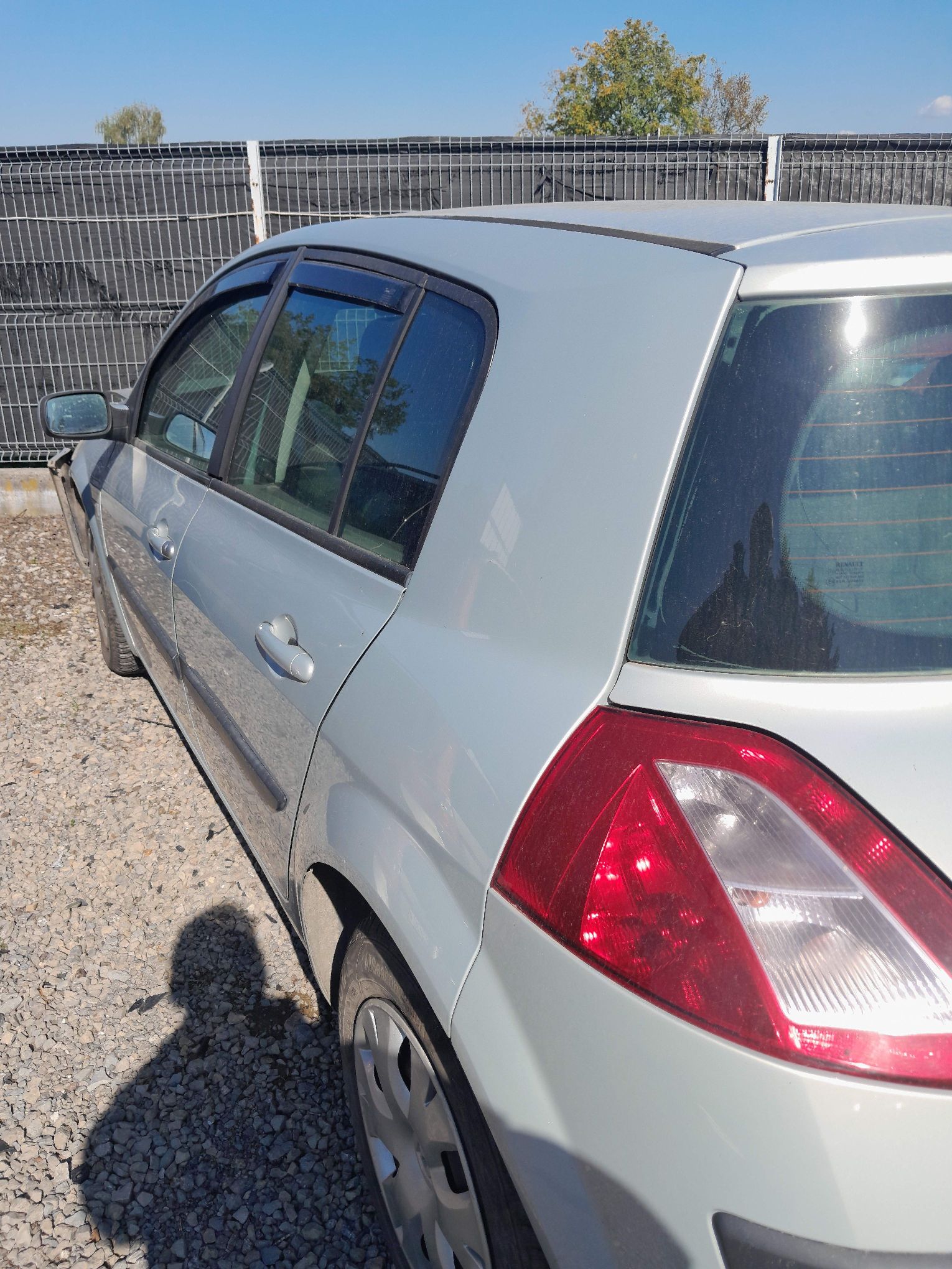 Srebrne Renault Megane widziane z lewej strony pojazdu.